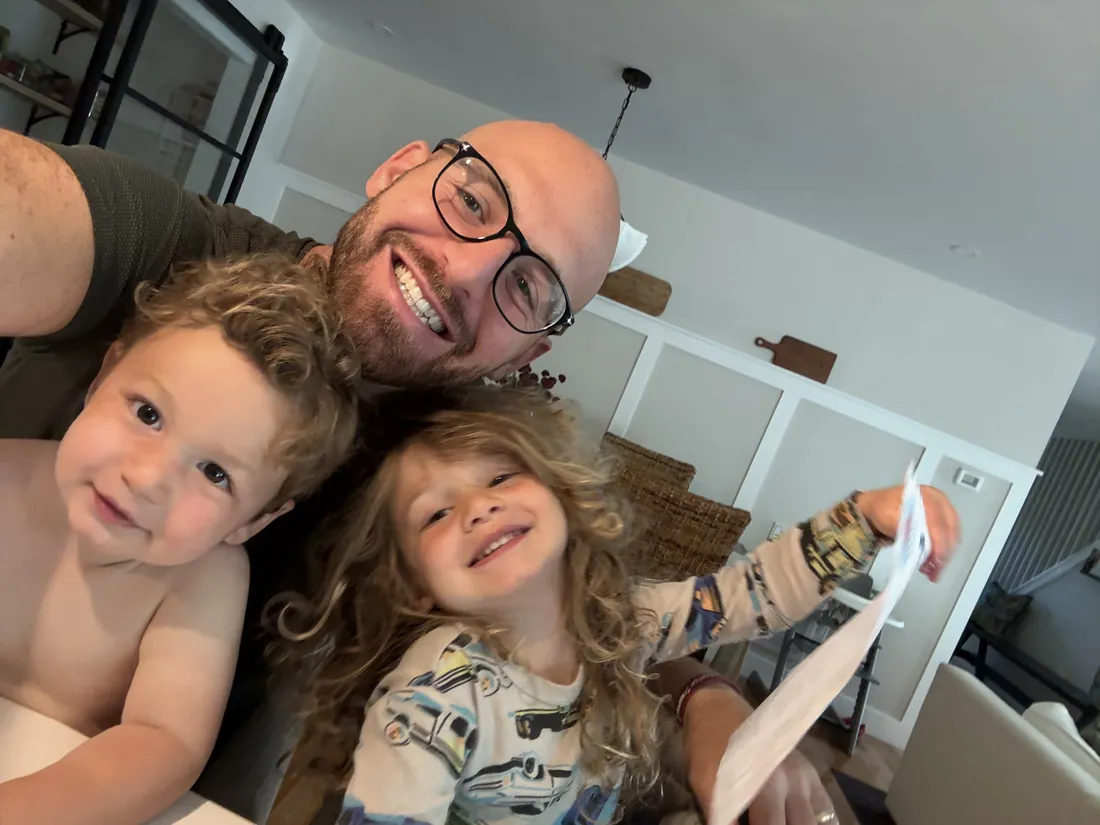A family smiling together while holding Zip's letter