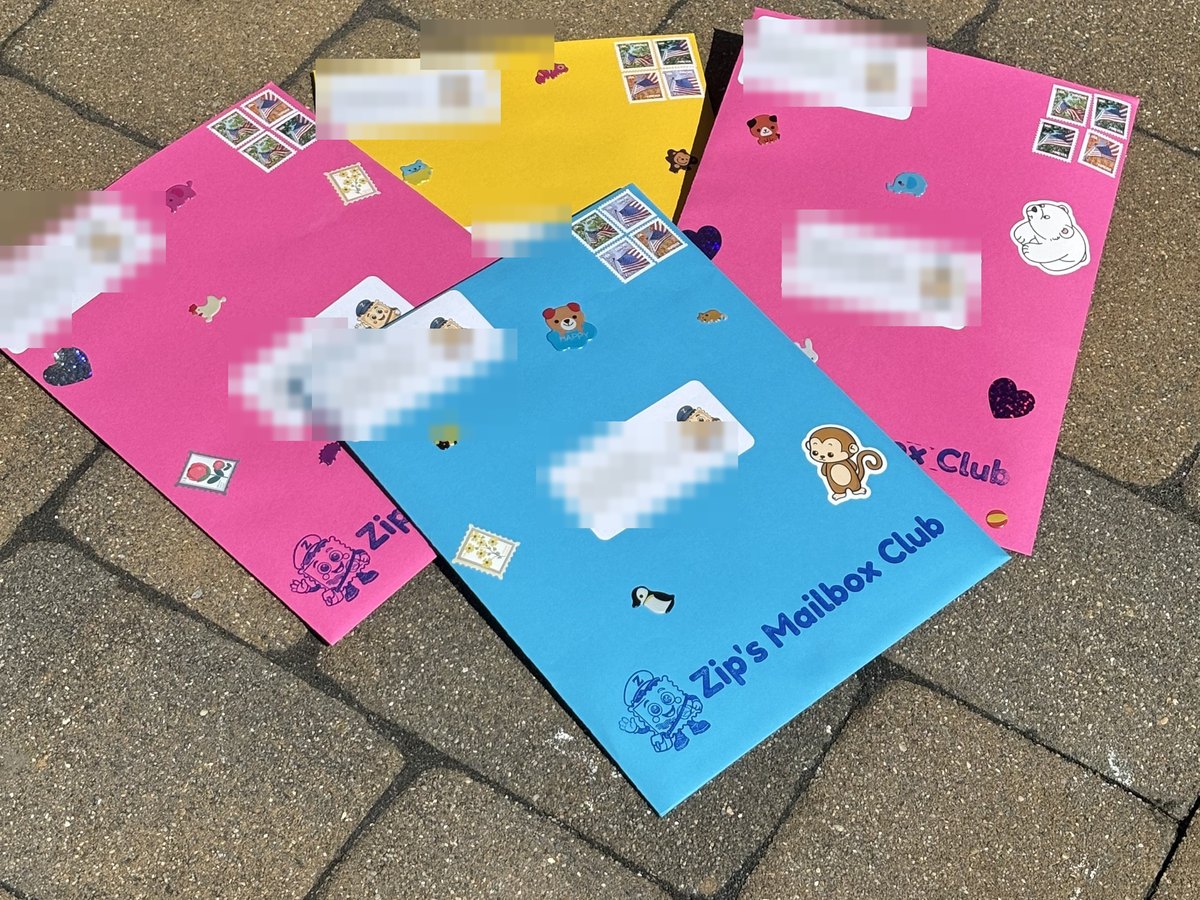 Four of Zip's colorful envelopes covered in stamps and stickers, addressed and ready to mail