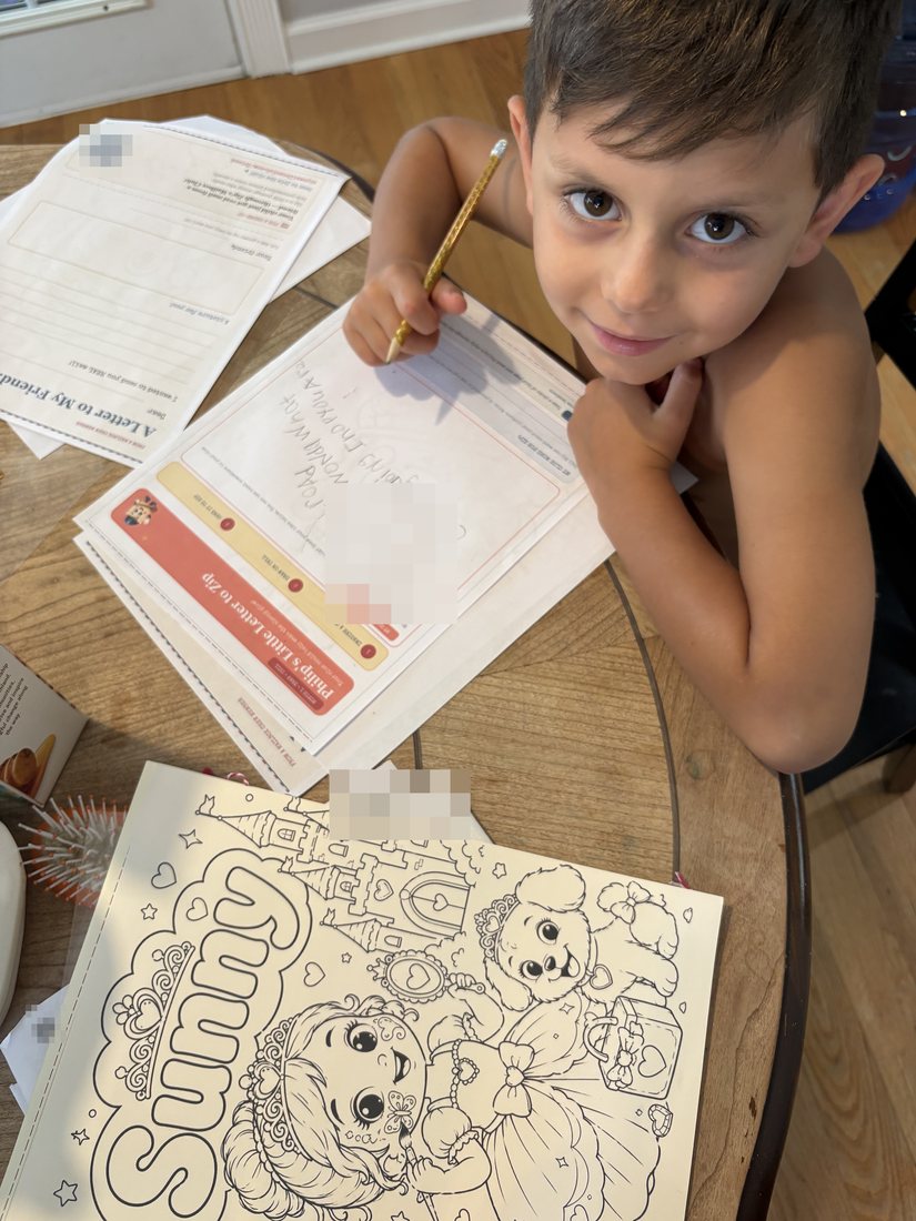 A boy at the kitchen table writing his letter back to Zip